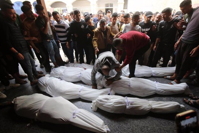 Palestinos junto a los cadáveres de varios muertos por un bombardeo del Ejército de Israel contra la ciudad de Gaza, en el norte de la Franja de Gaza (archivo)