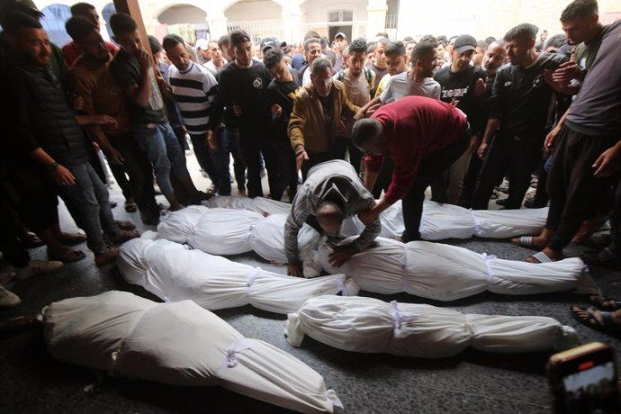 Palestinos ao lado dos corpos de várias pessoas mortas em um bombardeio do exército israelense na Cidade de Gaza, no norte da Faixa de Gaza (arquivo).