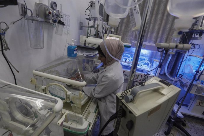 Archivo - Una trabajadora médica palestina atiende a bebés en un hospital de la Franja de Gaza en medio de la ofensiva militar del Ejército de Israel contra el enclave (archivo)