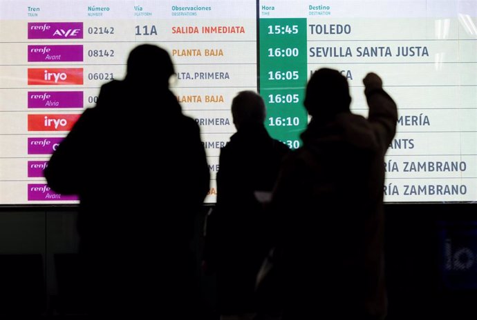 Archivo - Varias personas observan los paneles informativos en la estación de tren de Atocha-Almudena Grandes