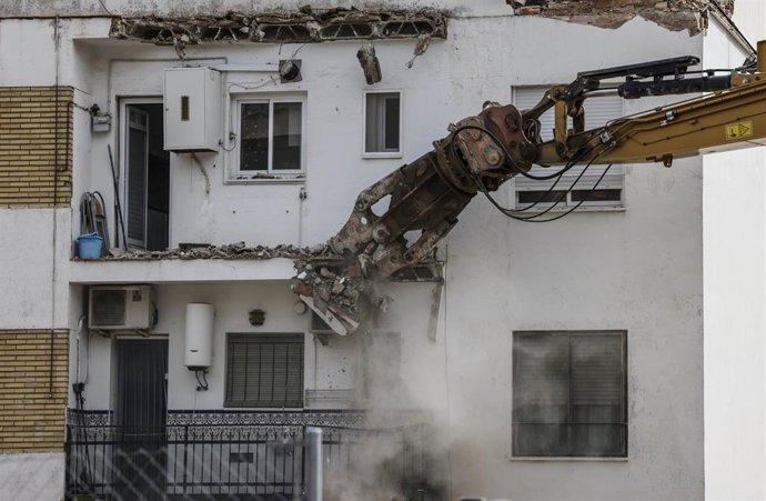 Archivo - Vecinos observan el derribo de viviendas con maquinaria pesada