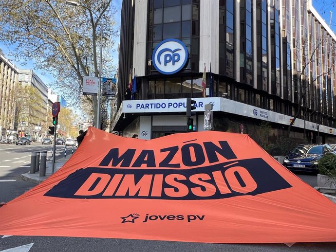 Jovens da Compromís exibem uma grande faixa em 'Génova' para exigir a renúncia de Mazón
