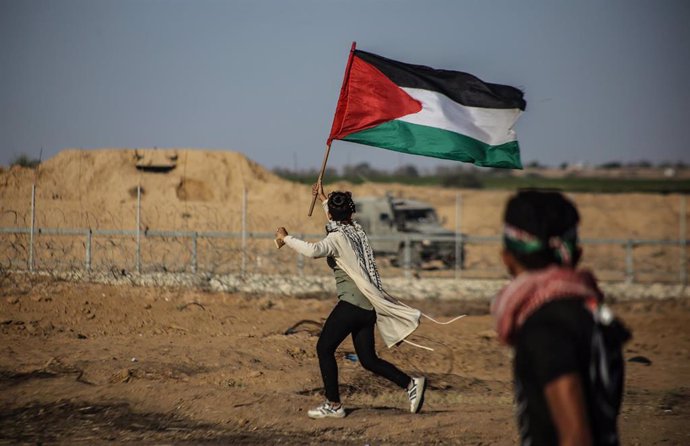 Archivo - Imagen de archivo de un joven en Jan Yunis ondeando la bandera palestina