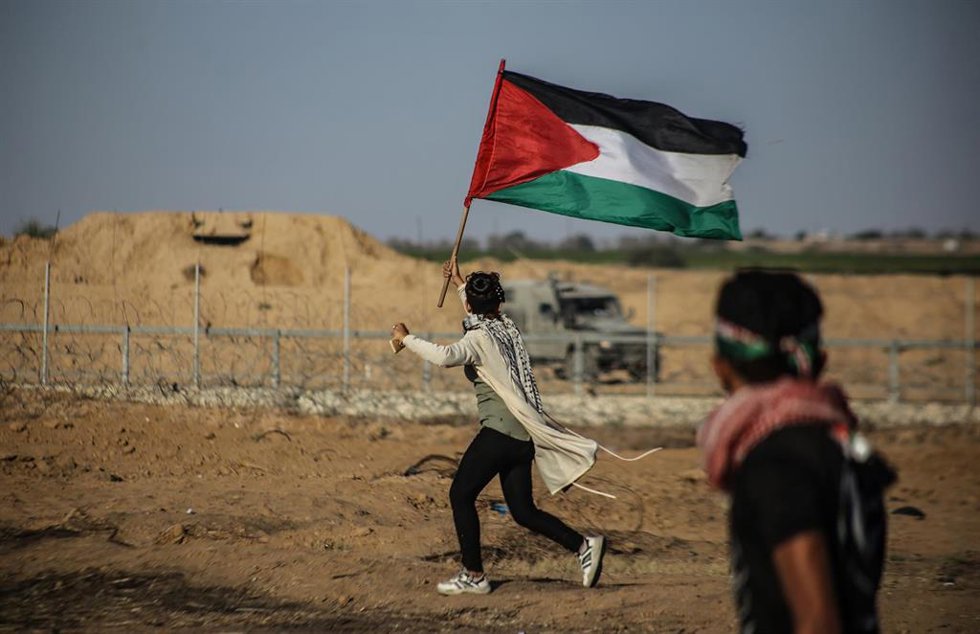 Archivo - Imagen de archivo de un joven en Jan Yunis ondeando la bandera palestina