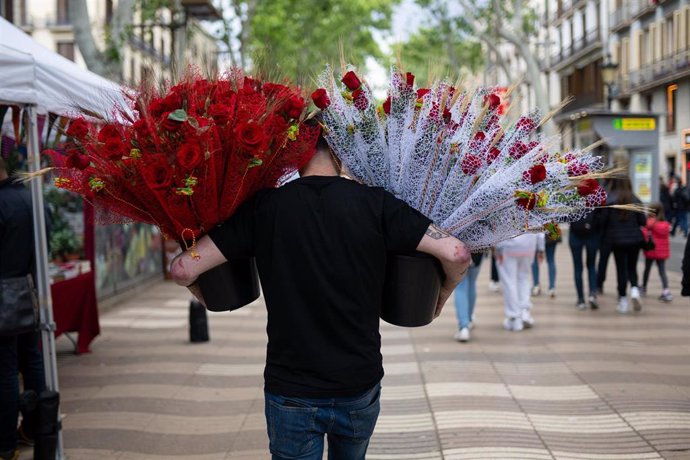 Archivo - Un hombre con rosas decenas de rosas rojas el día de Sant Jordi.