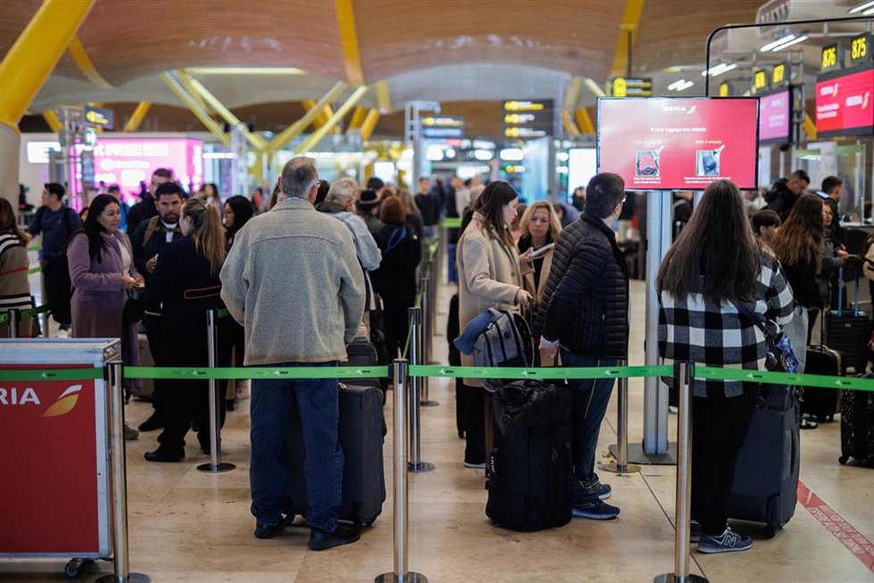 Archivo - Varias personas con maletas hacen cola en la terminal T4 del aeropuerto de Adolfo Suárez-Madrid Barajas