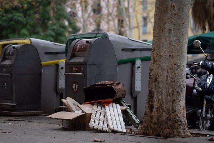 Archivo - Varias cajas en unos contenedores de basura