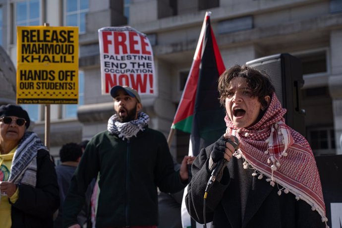 28 de março de 2025, EUA, Newark: Manifestantes seguram cartazes do lado de fora do Tribunal Distrital dos EUA em Nova Jersey, onde está ocorrendo uma audiência do tribunal de imigração no caso do ativista pró-palestino Mahmoud Khalil. Khalil, residente p