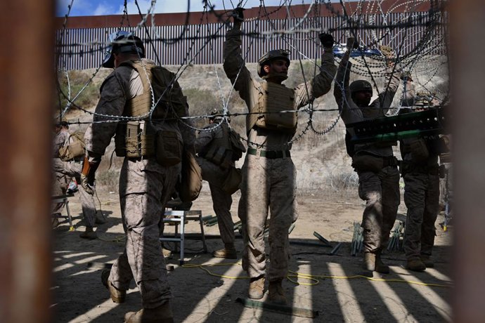 Archivo - February 6, 2025, Tijuana, Baja California, Mexico: Members of the US Marine Corps install concertina wire along the US-Mexico border wall in San Diego, California, seen from Tijuana, Mexico in between the San Diego-Tijuana border fences of Colo