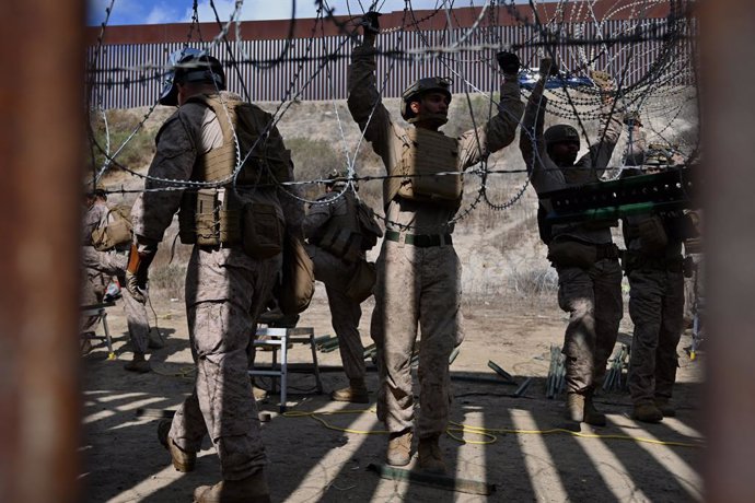 Archivo - Arquivo - 6 de fevereiro de 2025, Tijuana, Baja California, México: Membros do Corpo de Fuzileiros Navais dos EUA instalam arame de concertina ao longo do muro da fronteira entre os EUA e o México em San Diego, Califórnia, visto de Tijuana, Méxi