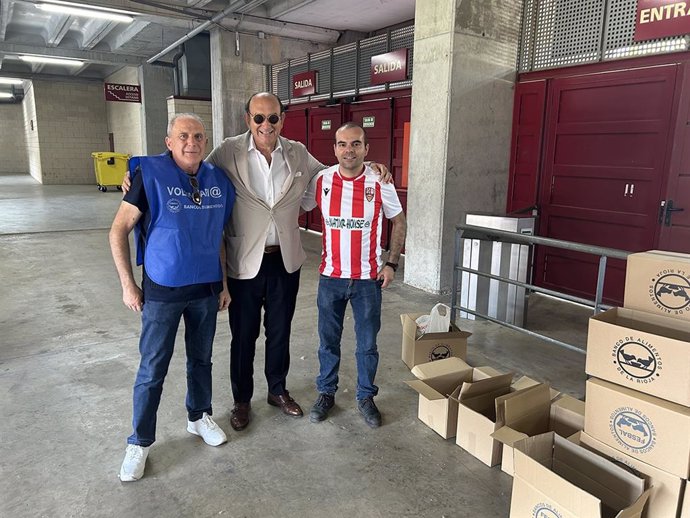 Archivo - El presidente de la UD Logroñés, Félix Revuelta, en el centro, junto a un voluntario del Banco de Aimentos y un miembro de una peña del club