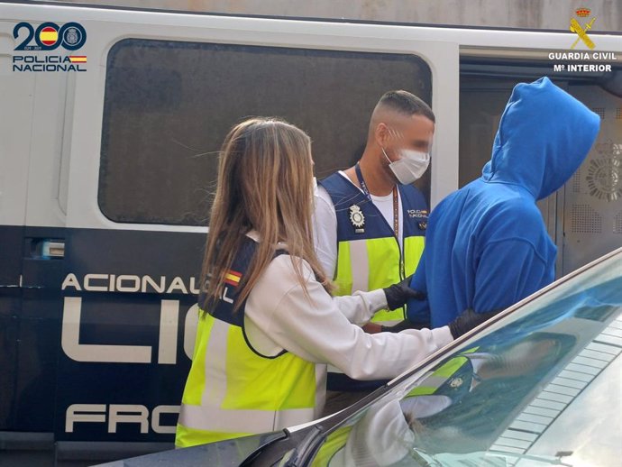 Agentes de la Policía Nacional acompañan a uno de los detenidos