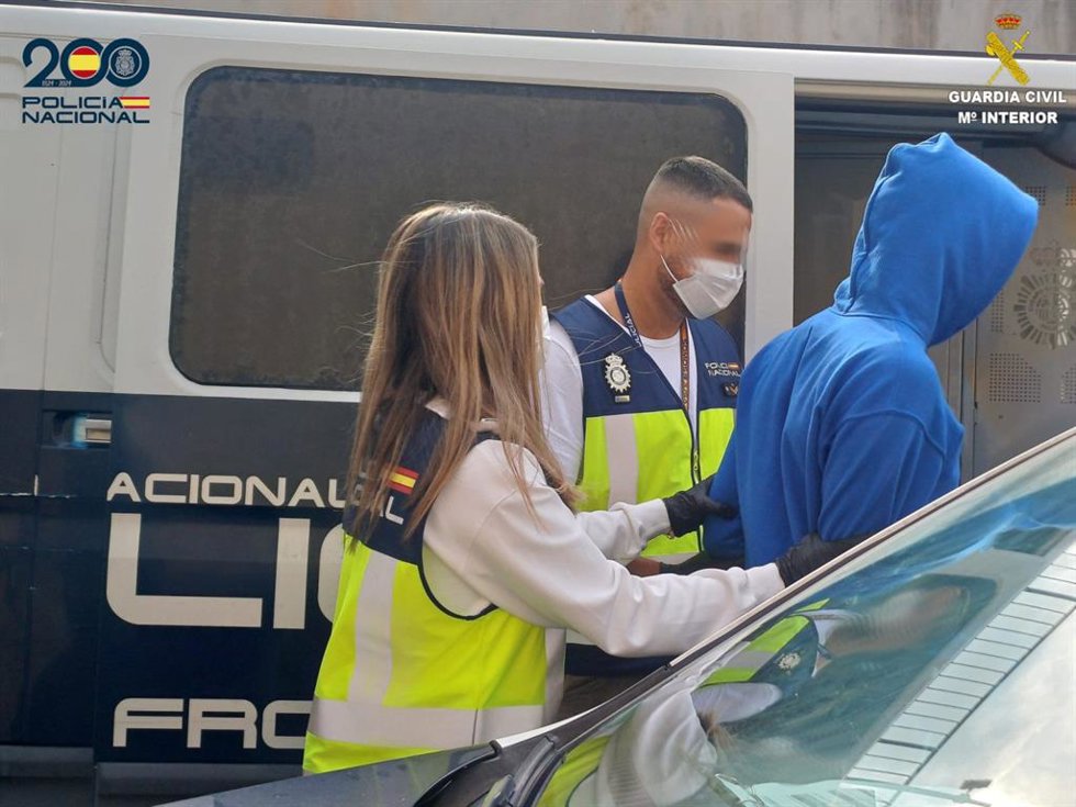 Agentes de la Policía Nacional acompañan a uno de los detenidos