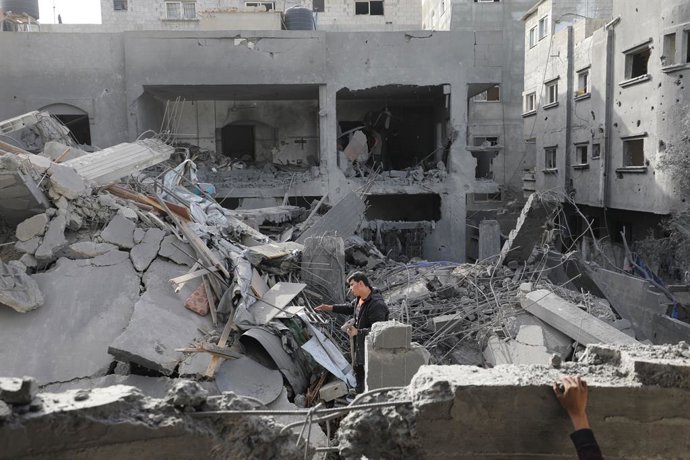 April 7, 2025, Dair El-Balah, Gaza Strip, Palestinian Territory: Residents examine the damaged houses after an airstrike carried out by the Israeli military on a four-story house belonging to the Garab family located on Akile Street of Deir al-Balah, Gaza