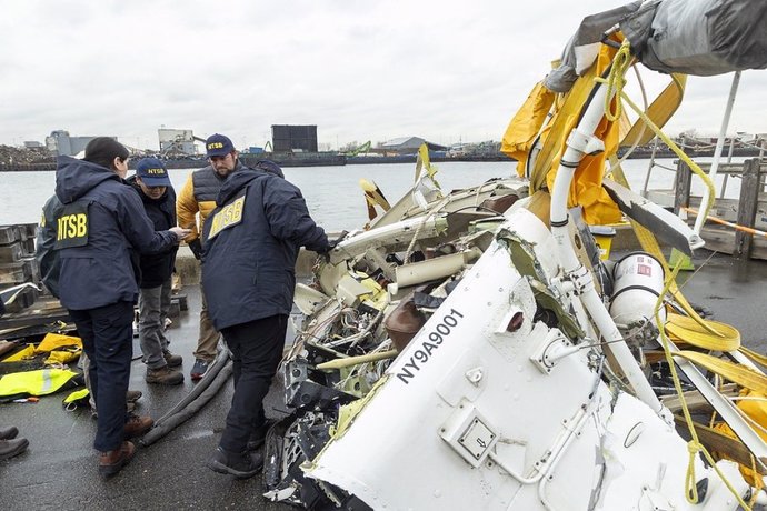 Inviestigadores examinan restos del helicóptero siniestrado en el río Hudson con una familia española a bordo