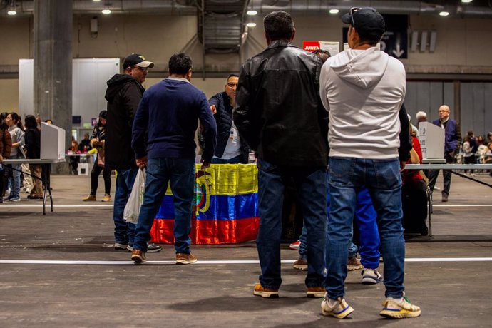 Un grupo de votantes espera para depositar su voto para la segunda vuelta de las elecciones presidenciales en Ecuador en el centro de votación preparado en IFEMA, en Madrid (España)