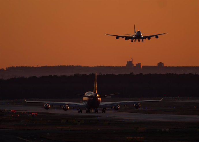 17 March 2025, Hesse, Frankfurt/Main: A Boeing 747 is approaching Frankfurt Airport in the last light of day, while another aircraft of the same type taxis to its position. Photo: Boris Roessler/dpa