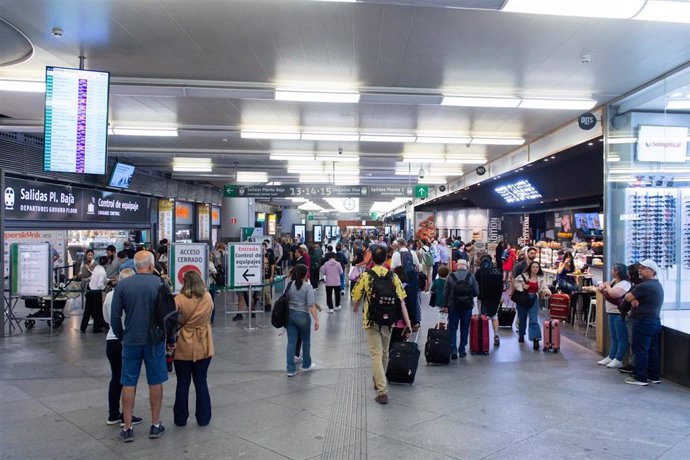 Archivo - Varias personas caminan con maletas en la estación de Puerta de Atocha-Almudena Grandes, con motivo del inicio del puente del Pilar, a 11 de octubre de 2023, en Madrid (España). Renfe ofrece cerca de 1,3 millones de plazas en sus trenes AVE, Avl