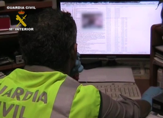 Archivo - Un agente de la Guardia Civil observa una pantalla de ordenador.