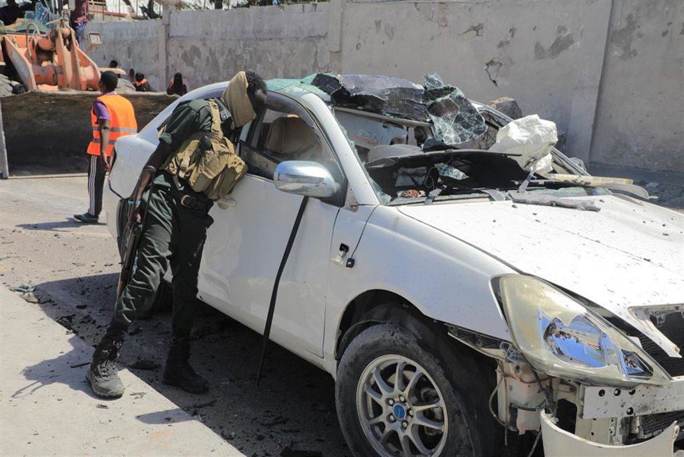 Archivo - Un miembro de seguridad revisa un vehículo en la escena de un ataque suicida con coche bomba en Mogadiscio, Somalia (archivo)