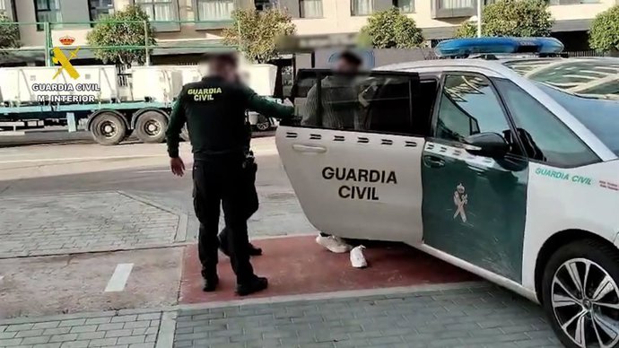 Agentes de la Guardia Civil introducen a un detenido en un coche