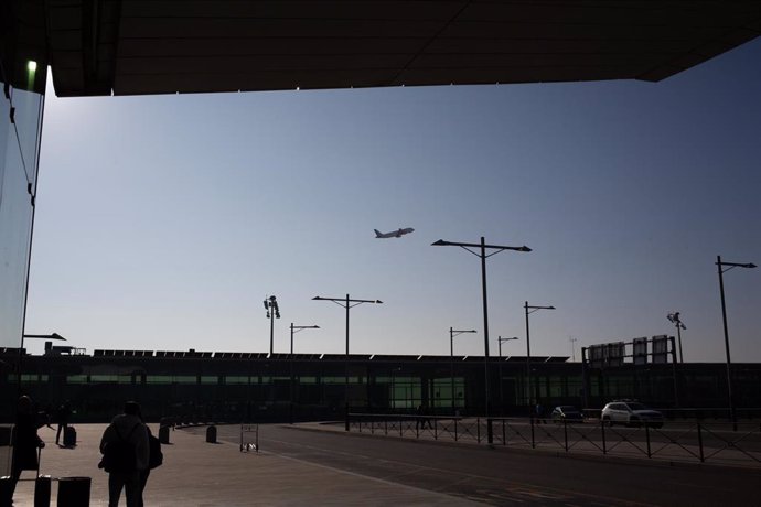 Archivo - Un avión sobrevuela el Aeropuerto de Barcelona-El Prat.