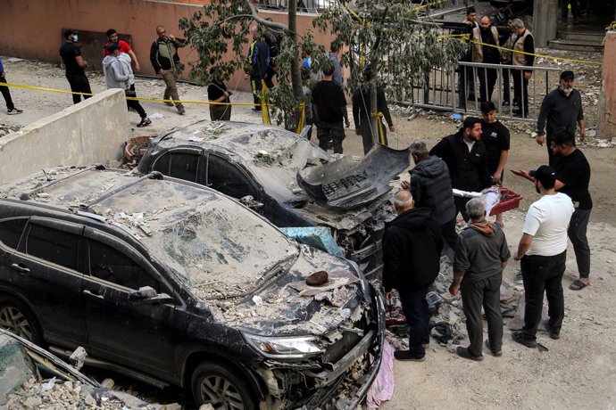 01 de abril de 2025, Líbano, Beirute: Pessoas inspecionam carros destruídos depois que um ataque aéreo israelense atingiu um prédio nos subúrbios do sul de Beirute, um reduto do Hezbollah, danificando seus andares superiores. O ataque, que ocorreu por vol