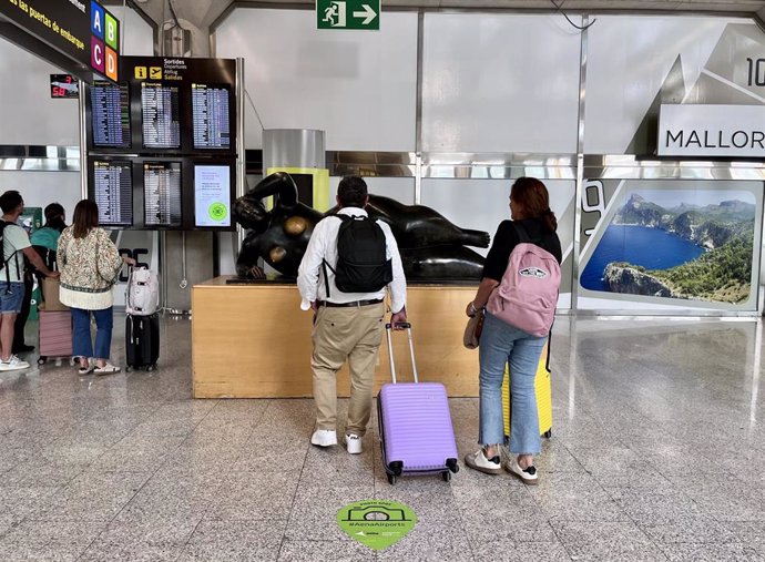 Archivo - Pasajeros frente a una escultura en el aeropuerto de Palma.