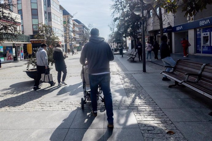 Archivo - Un hombre lleva un carrito de bebé.