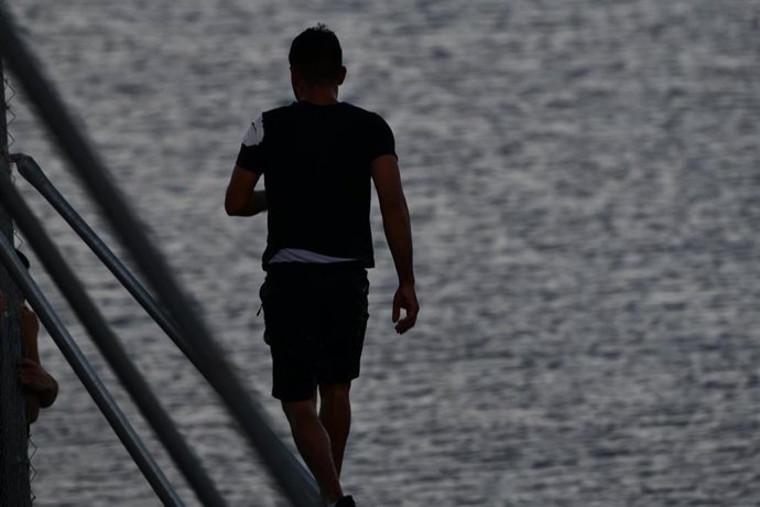 Archivo - Imagen de archivo de un migrante caminando por la playa del Tarajal. En Ceuta, en mayo de 2021