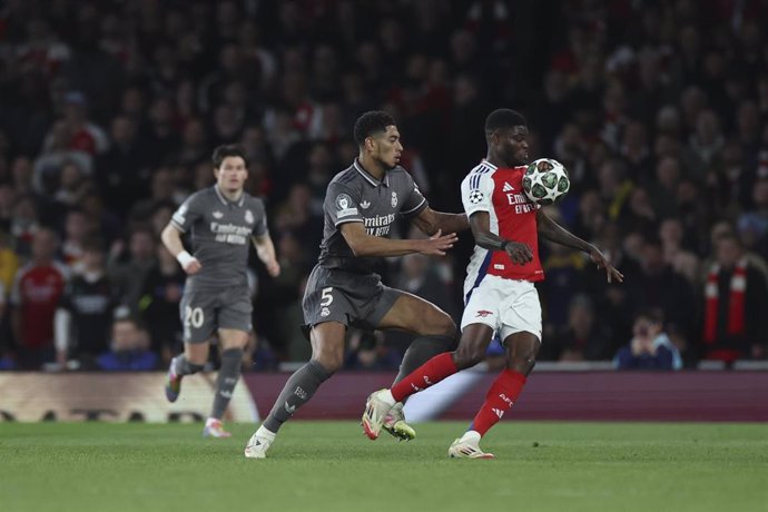 El jugador del Arsenal Thomas Partey intenta controlar el balón ante el futbolista del Real Madrid Jude Bellingham en la ida de cuartos de final de la Champions en el Emirates Stadium. 