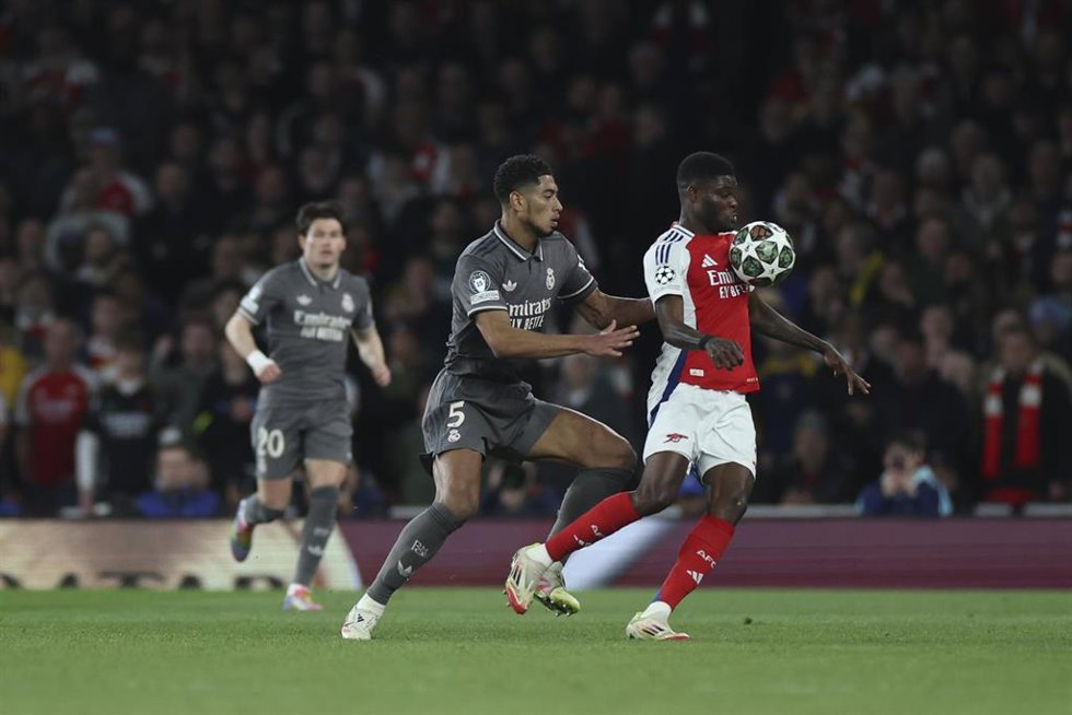 El jugador del Arsenal Thomas Partey intenta controlar el balón ante el futbolista del Real Madrid Jude Bellingham en la ida de cuartos de final de la Champions en el Emirates Stadium. 