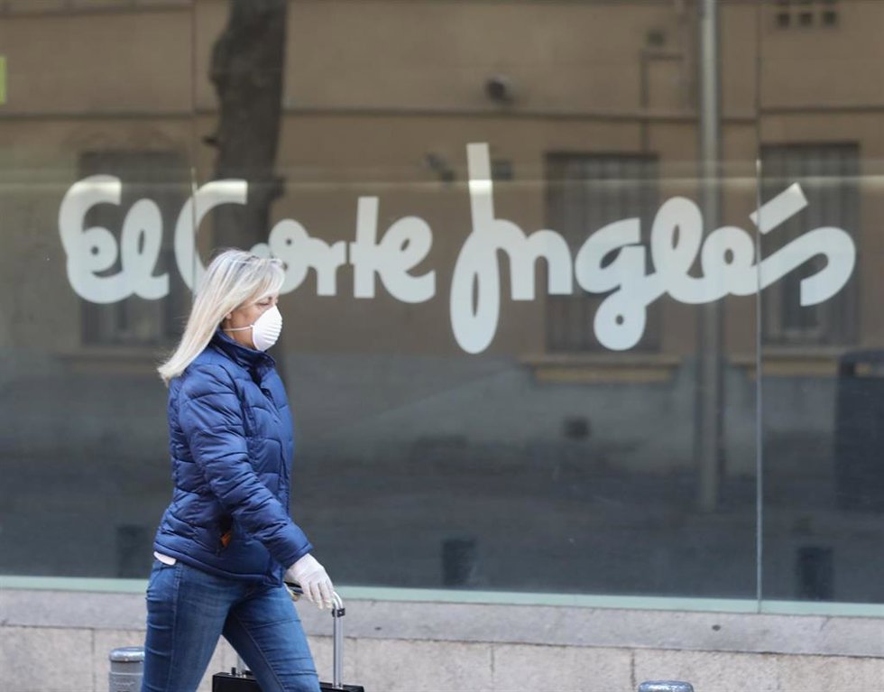 Archivo - Una mujer pasa al lado de uno de los centros del Corte Inglés, en imagen de archivo en Madrid