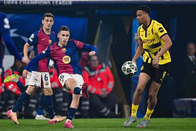 15 de abril de 2025, Renânia do Norte-Vestfália, Dortmund: Fermin López (esq.), do Barcelona, e Felix Nmecha, do Dortmund, disputam a bola durante a partida de futebol de volta das quartas de final da Liga dos Campeões da UEFA entre Borussia Dortmund e FC