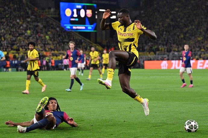 Barcelona's Jules Kounde (L) and Dortmund's Serhou Guirassy battle for the ball during the UEFA Champions League quarter-final second leg soccer match between Borussia Dortmund and FC Barcelona at the Signal Iduna Park