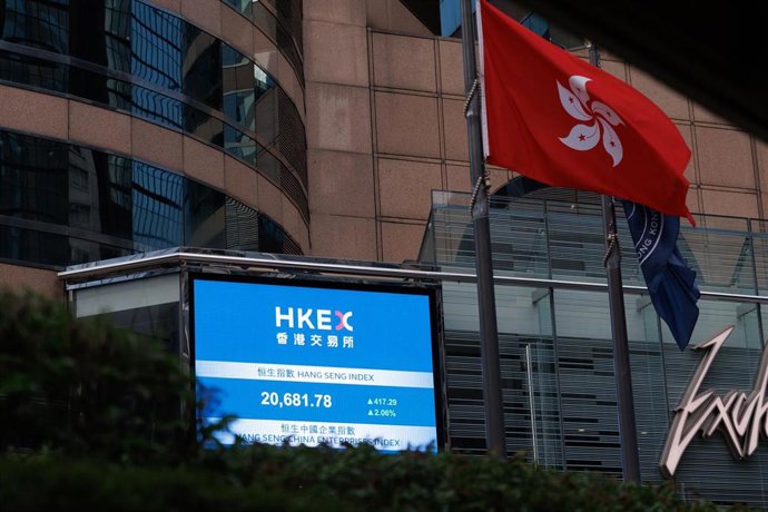 Bandera de Hong Kong frente a una pantalla que muestra el precio del índice Hang Seng en Exchange Square