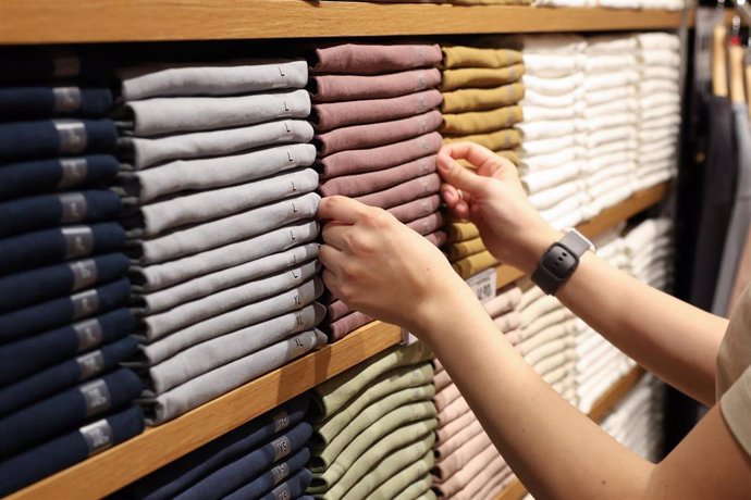 Una dependienta coloca la ropa en una tienda