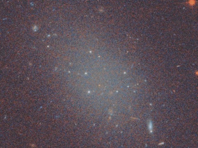 Imagem pseudocolorida da galáxia ultra-difusa FCC 224, localizada no aglomerado Fornax, capturada pelo Telescópio Espacial Hubble (HST).