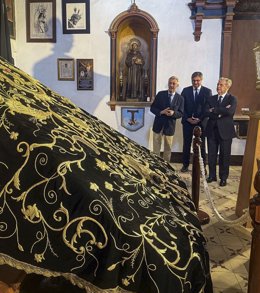 Salvador Fuente (dcha.) observa el manto procesional de la Virgen de La Soledad de Puente Genil ya restaurado.