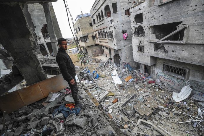 GAZA, 20 de março de 2025 -- Um homem palestino em pé em um prédio destruído após um ataque aéreo israelense na cidade de Beit Lahia, no norte da Faixa de Gaza, em 20 de março de 2025. Os militares israelenses disseram na quinta-feira que suas forças inic