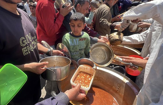 15 de abril de 2025, Nusairat, Faixa de Gaza, Território Palestino: Palestinos se reúnem em grande número para receber as refeições distribuídas por instituições de caridade no campo de refugiados de Nuseirat, na parte central de Gaza, em 15 de abril de 2