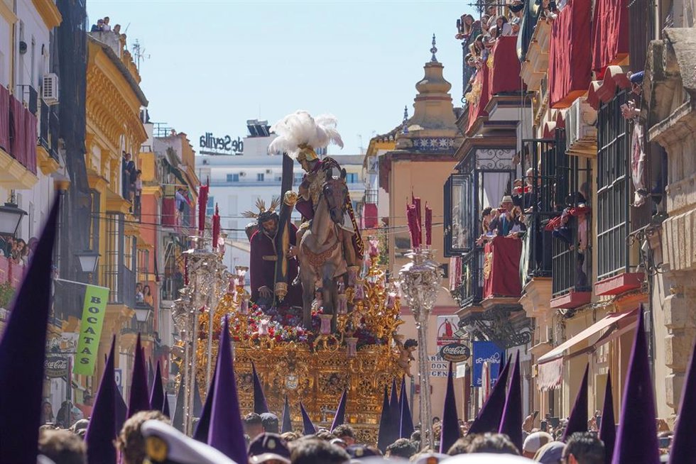 Archivo - El paso del Cristo de las Tres Caídas, precedido por nazarenos con antifaces morados, en la calle Pureza antes de entrar en la Capilla de los Marineros. 