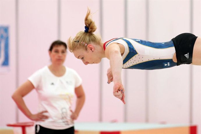FILED - 25 July 2012, United Kingdom, London: German coach Claudia Schunk (L) watches gymnast Janine Berger during a training session in Greenwich Academy at the London 2012 Olympic Games.