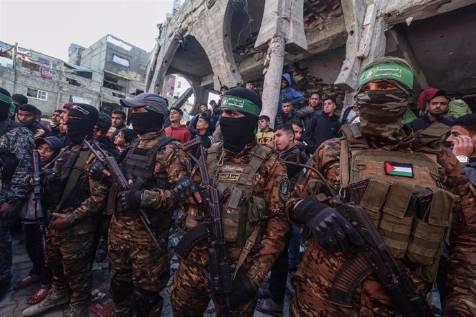 Archivo - Imagen de archivo de miembros del brazo militar del Movimiento de Resistencia Islámica (Hamás), las Brigadas Ezzeldín al Qassam, en la Franja de Gaza frente a edificios destruidos por los ataques de Israel