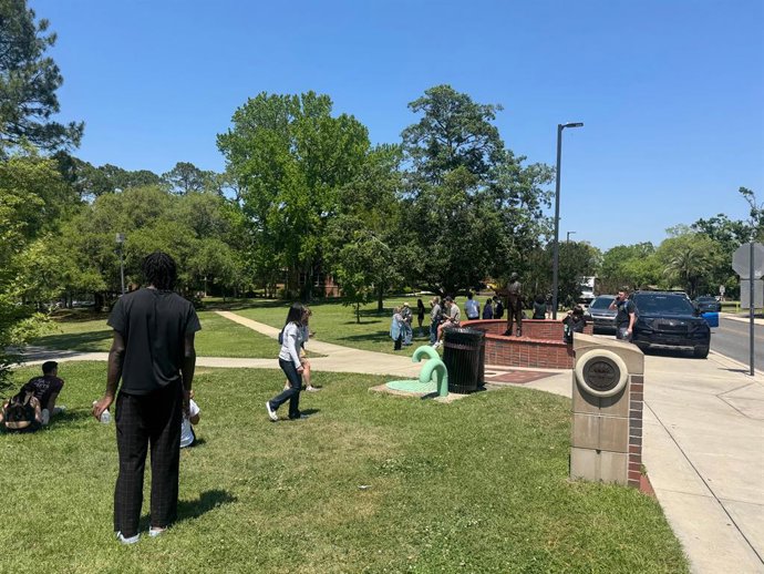 17 de abril de 2025, Tallahassee, Flórida, EUA: Estudantes e professores da Universidade Estadual da Flórida aguardam em uma área gramada perto do sindicato dos estudantes, onde foi registrado um tiroteio. Pelo menos uma pessoa morreu e outra está sob cus