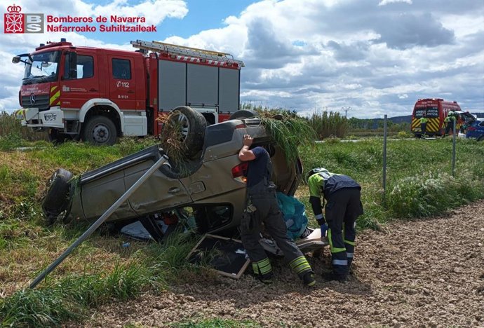 Los bomberos intervienen en el coche accidentado.