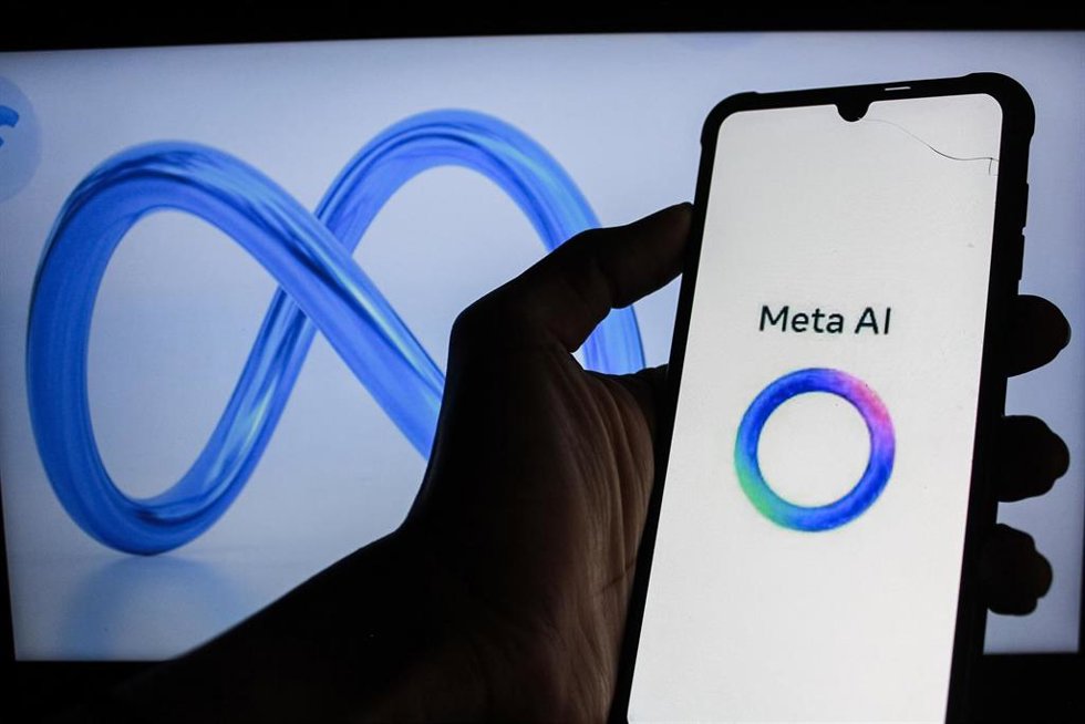 Archivo - Logo de Meta AI en la pantalla de un smartphone y de la empresa Meta al fondo