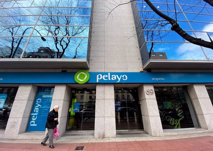 Archivo - Una persona pasa por delante de una oficina de la compañía aseguradora Pelayo, en Madrid a 17 de diciembre de 2019.