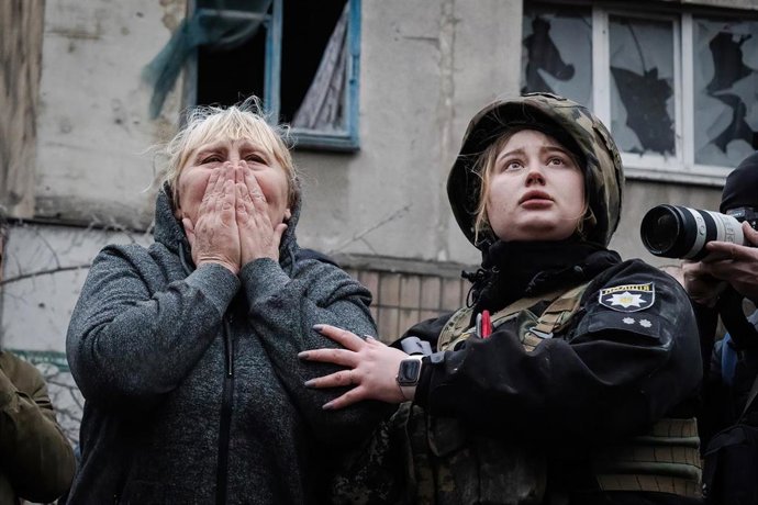 Archivo - Una mujer ucraniana junto a a una agente de la Policía se lamenta tras un ataque ruso en Sloviansk, en la provincia de Donetsk.