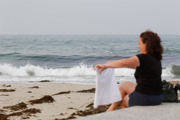 Archivo - Una mujer durante la pleamar en el espigón de Foz, junto a la playa de A Rapadoira, a 19 de septiembre de 2024, en Lugo, Galicia (España).